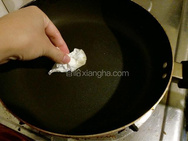 用纸巾沾食用油在平底锅上抹一层油。