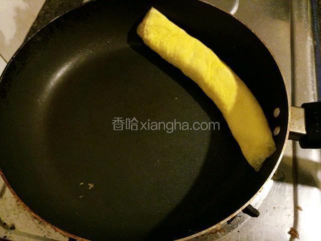 待蛋液半凝固的时候将蛋卷从左边卷起来到另一侧。