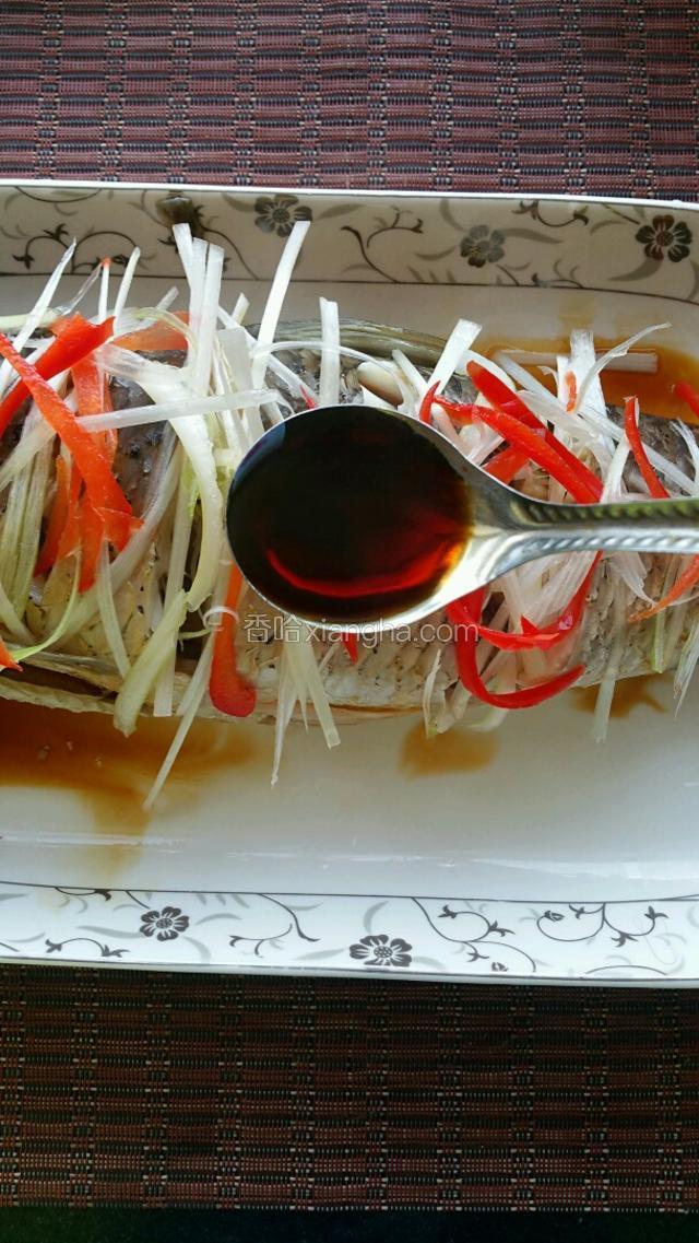 蒸好的鱼去除多余的汤汁，把泡好水的葱丝和红椒丝放在鱼身上，在淋上3勺蒸鱼吃油。