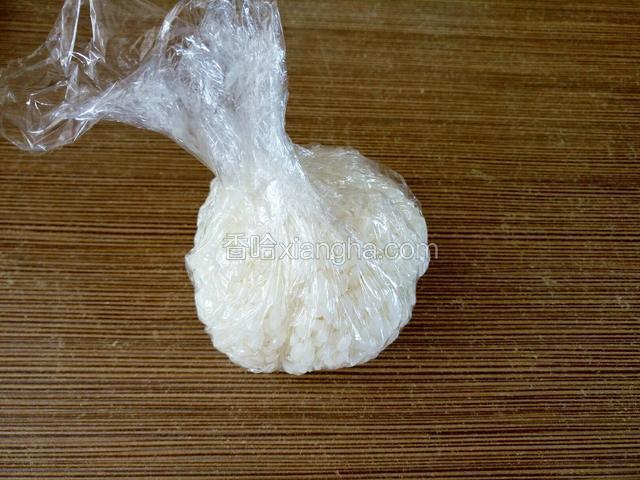 把保鲜膜收起来将米饭包在里面。（其实用保鲜袋更方便些）