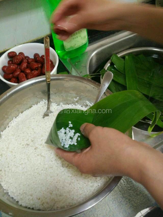 取两片苇叶平行略叠加，将根部剪齐，向内折成勺型