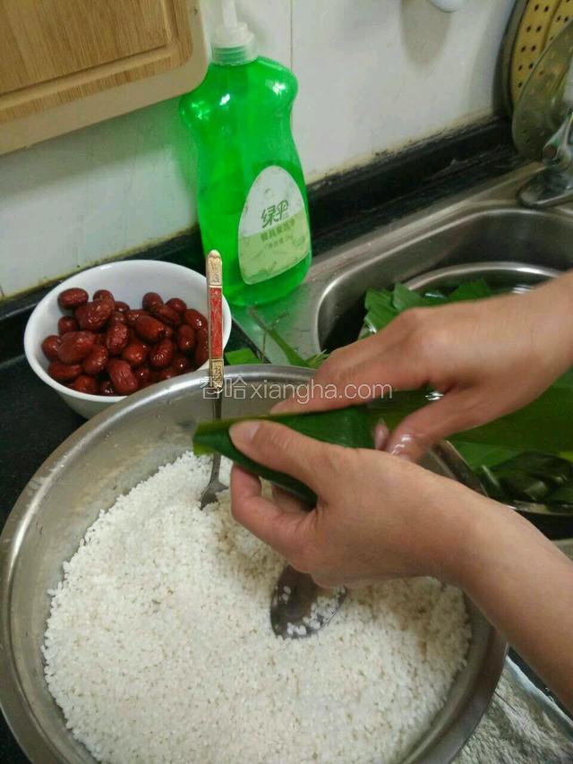 再取一片稍长的苇叶放在粽子的右侧