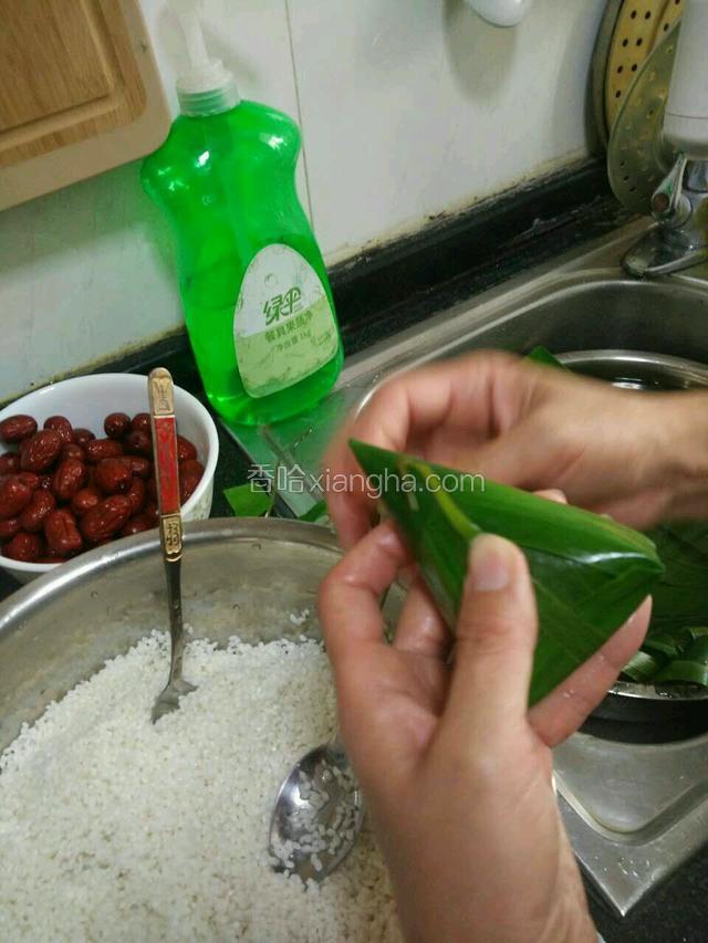 针插入粽子尖靠下2厘米的位置，将叶尖穿进粽子针，并从背后抽出