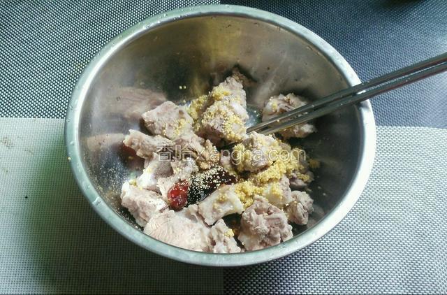 把排骨放大碗了，倒入所有调味料跟小米搅拌均匀。