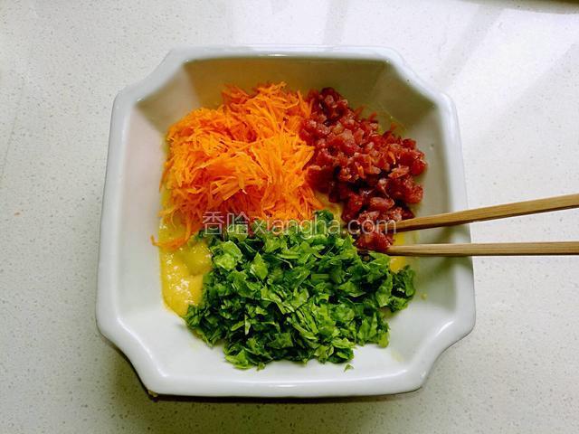 把胡萝卜丝，生菜丁和腊肠丁倒在鸡蛋土豆糊中。