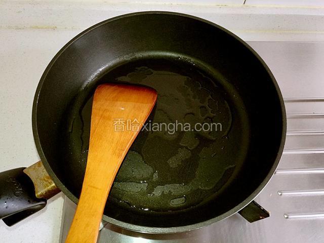 不粘锅中倒油烧热。