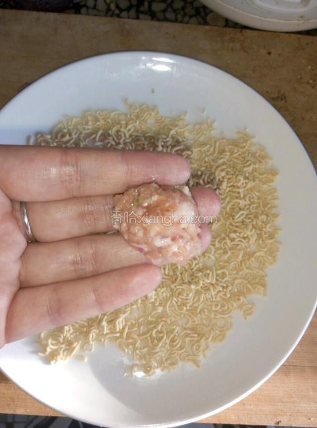 捏适量大小的肉球在面饼碎里滚