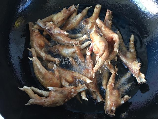 油炸的过程中盖上锅盖(以免煎到自己），用中火炸至五六分钟左右鸡爪翻翻身再炸，鸡爪炸至金黄干瘪即可捞出。