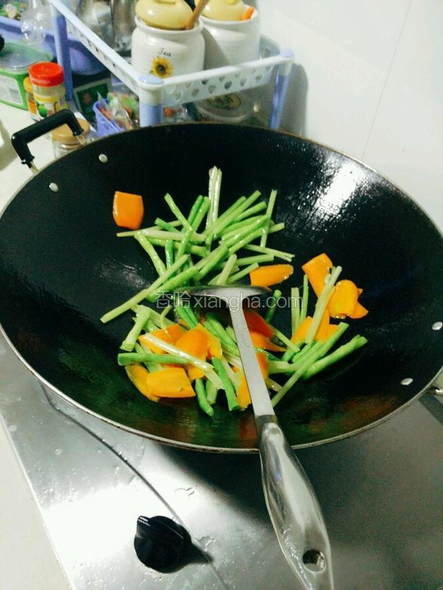 再热油放豆角、芹菜和红萝卜，炒断生为止。