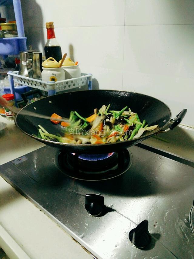 把刚炒过的香菇、木耳、腐竹倒回锅里，和豆角等食材一起炒。