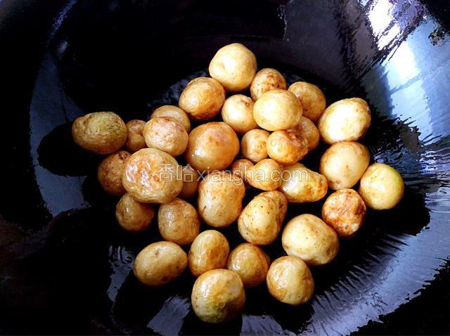 锅中加油烧热倒入土豆炒至外皮金黄色
