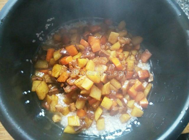 将炒好的腊肉和土豆倒入电饭锅中