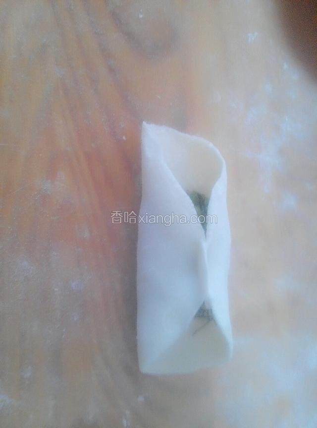 把饺子皮中间对折捏住