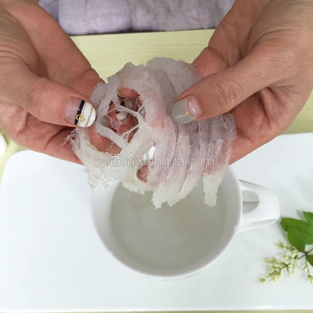 把泡好的燕窝撕成小条，换水轻轻抓洗几遍，把残留的小小细毛洗出来