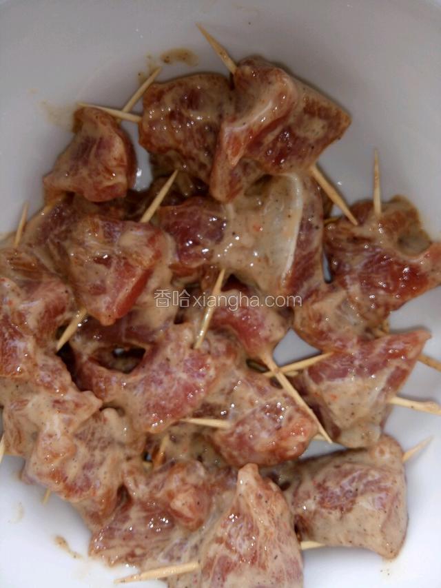 倒上鸡蛋液，撒上干淀粉抓匀，然后再一块一块肉插上牙签待用。