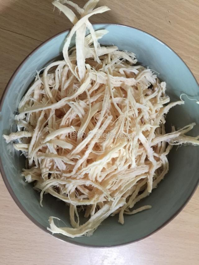 将煮熟的鸡胸肉捞出后晾凉，然后用手沿着鸡肉的纹理仔细地撕成鸡丝。