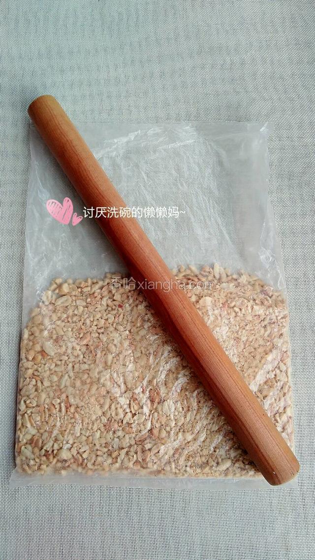 将花生仁放进保鲜袋，用擀面杖擀成花生碎。