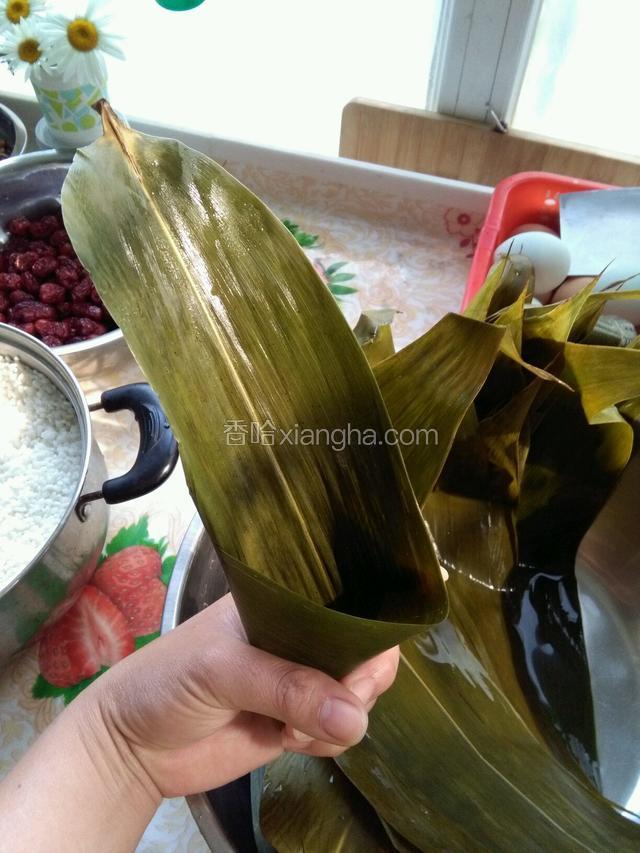 把粽子叶握成漏斗形，但要注意底部不能留孔喔。