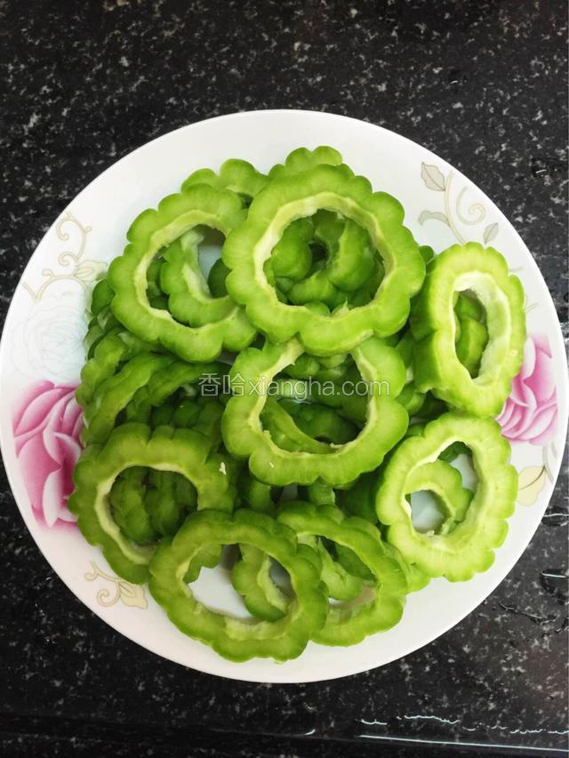 苦瓜洗净，把里面的籽，苦瓜白色那层去掉，不然会很苦，切成一节节，或者一个圈（自己随意）