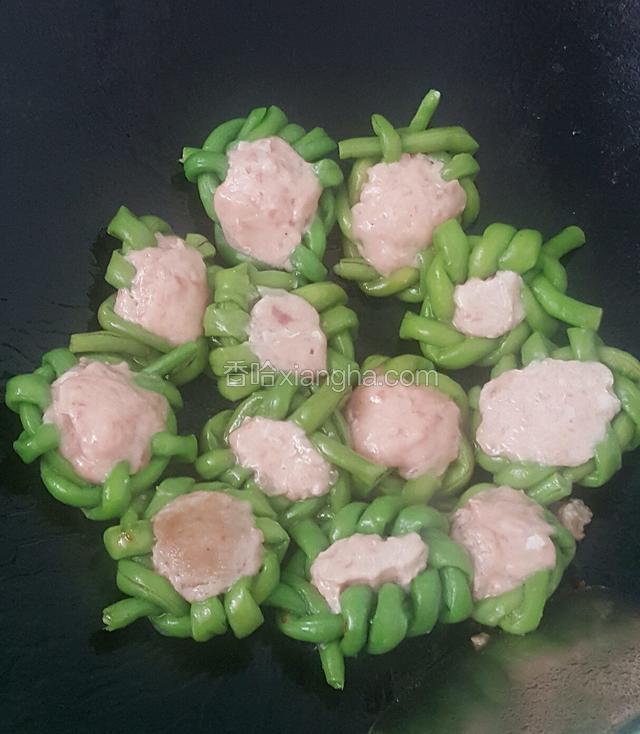 大火热锅，均匀地把花生油倒进去冒烟了就把豆角倒进去转中火煎