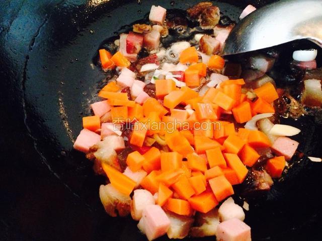 把辣肉炒出香味后放入胡萝卜煸炒片刻。