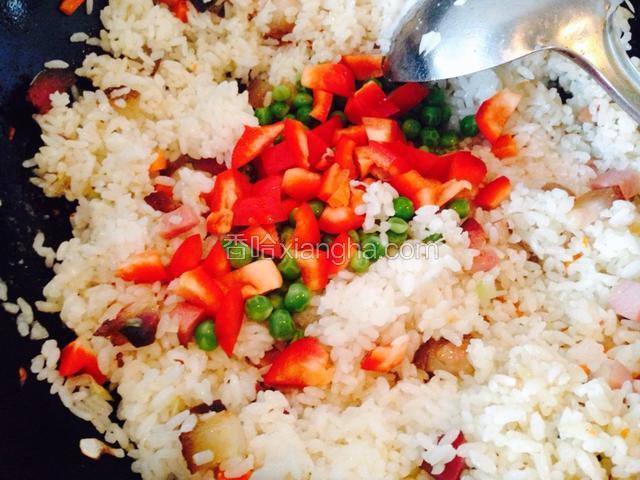 出锅前放彩椒丁和焯熟的豌豆进行翻炒。