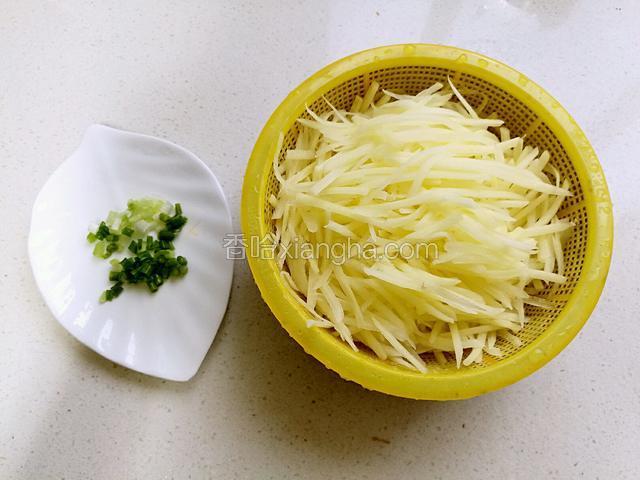 把土豆丝捞起控干水份，小葱切未。