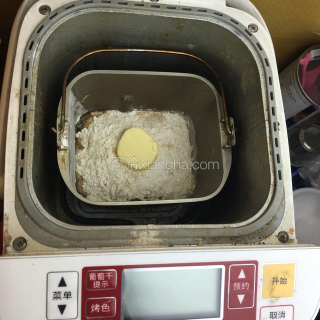 将面包放入面包机内，再将酵母放入酵母槽内，选择菜单中的程序，然后启动开关！