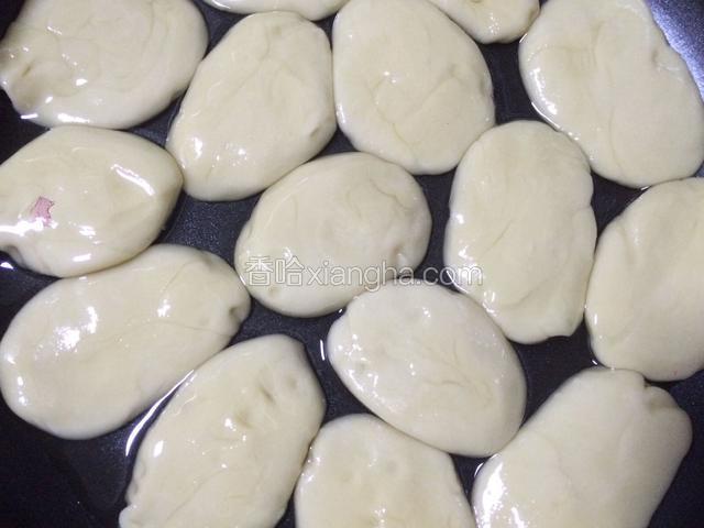将面团压扁，放入食用油中浸泡一下