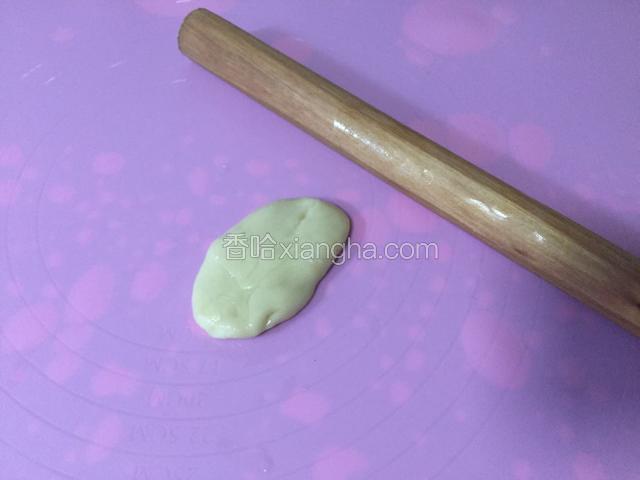将面团从食用油中取出，用擀面杖将面团擀成长长的薄薄的面皮