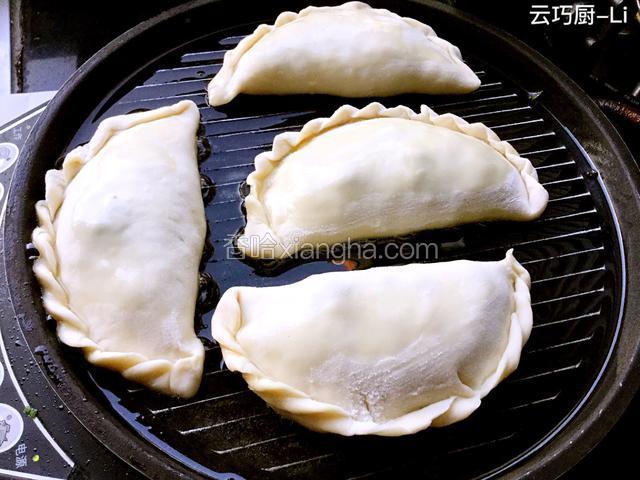 电饼铛抹上花生油，加热把包好的韭菜盒放进去，在皮上再抹上点花生油盖上，开到煎馅饼档上开始煎。
