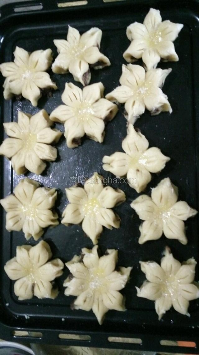 然后把烤盘抹上油    一个个的放在烤盘上   用手指头  沾点蛋黄  抹在葵花酥的中间   （花心）有黑芝麻  在抹的蛋黄上放几粒黑芝麻      上烤箱  烤30分钟   下火160℃   上火150℃