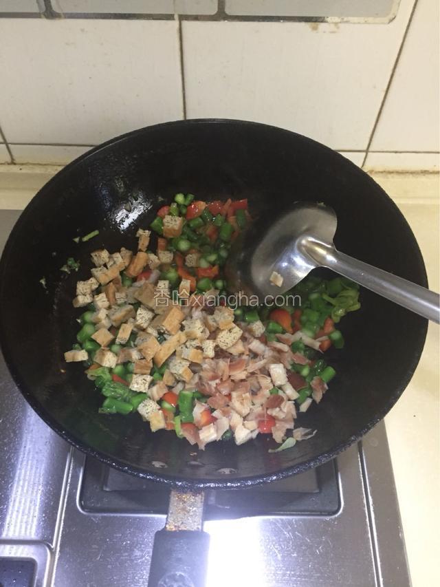 倒入鱿鱼丁和豆腐丁翻炒片刻后加入1茶匙盐。