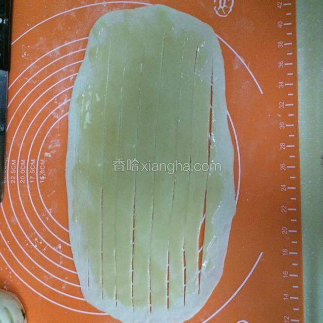 在薄面皮上面涂上薄薄一层油酥，撒上葱花再用刀划成均为的片块，注意四周不要切断。
