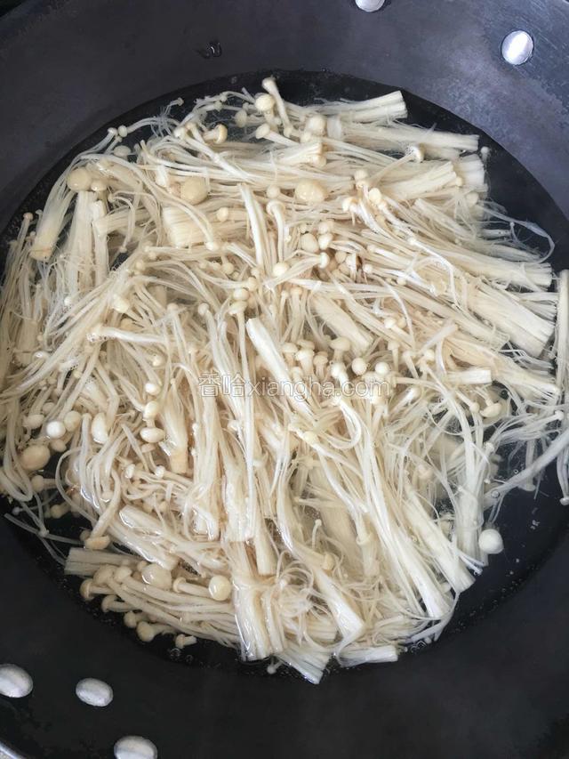金针菇过沸水焯一下,再冲洗干净,沥干水分。
