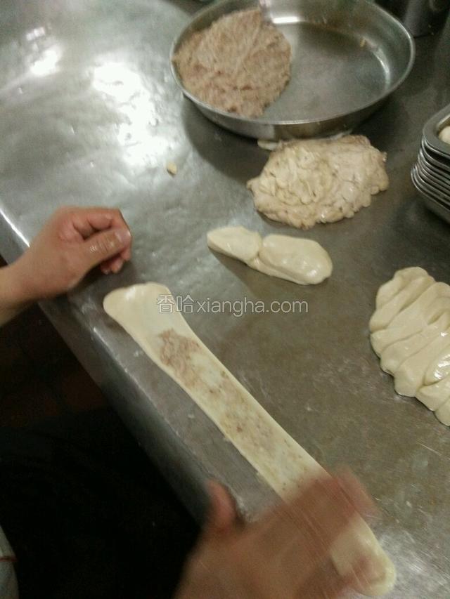 面饼醒好后手抓住两边均匀拉开，在抹上拌好的猪油，如图：