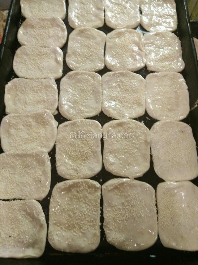 烤的时候烤箱预热上火270下火300，解冻的面胚封口朝上然后用手按成长方形，在反过来放到烤盘里，上面刷上蛋黄，在撒芝麻，放入烤箱烤之表面焦黄，一般烤七之八分钟就可以了