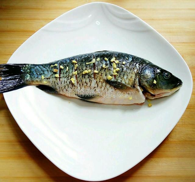 将盐腌后的鱼用清水洗净，再依次抹上料酒、少量盐、胡椒面，鱼肚里放一节大葱，洒上花椒粒、姜粒腌30分钟左右