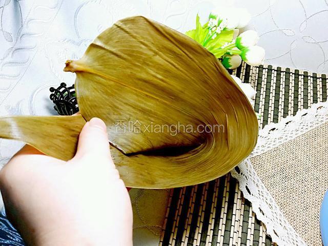 將一块粽葉對折成角形