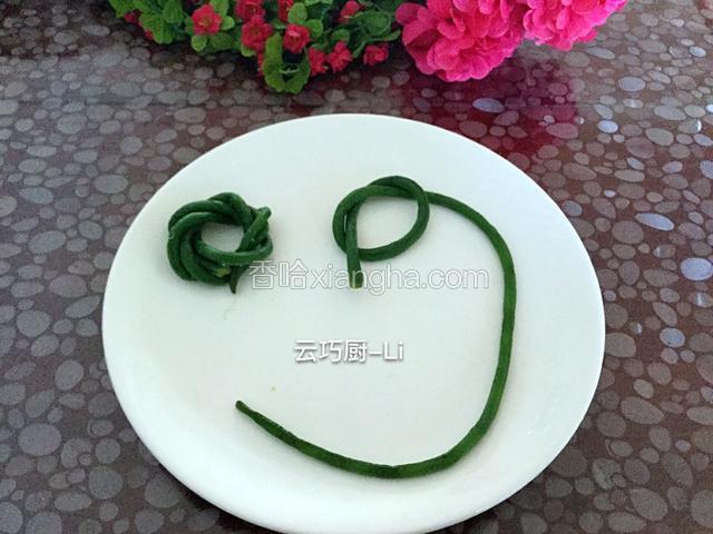 控干水分，豇豆打成结如图盘好，两头压住。