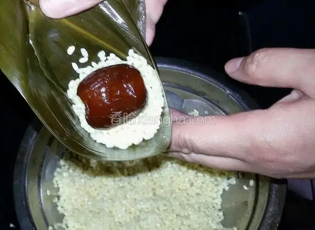 然后放糯米，放一颗蜜枣。