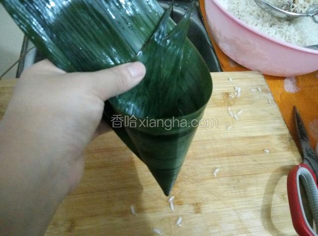 取两片大小一样的粽叶，打成漏斗状