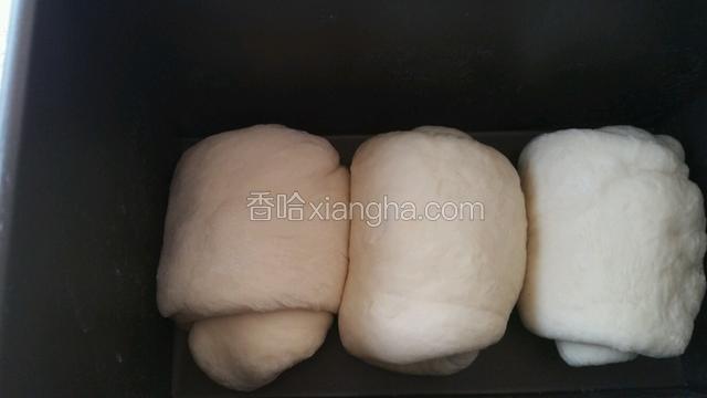 5分钟后再次将面擀皮牛舌状卷起放入吐司盒，入烤箱开启醒发功能或加入一碗温水醒发。