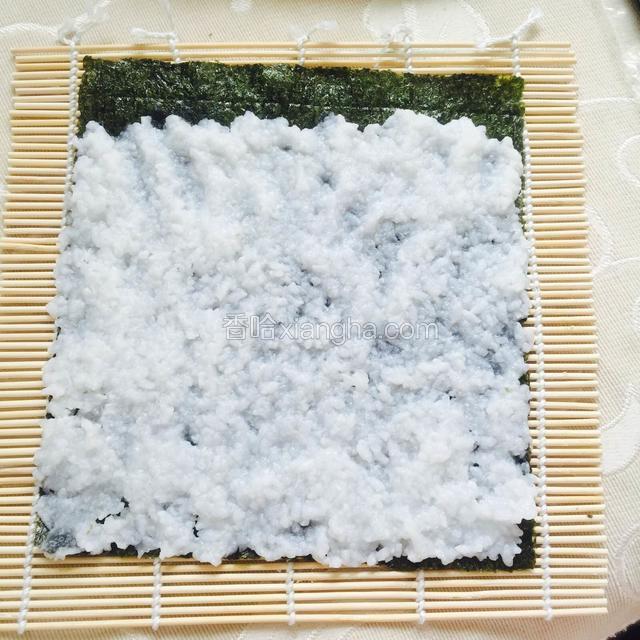 拿出两张紫菜铺好，米饭倒在上面，用手弄散，铺满紫菜的四分之三的每个角落
