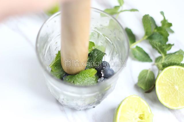 2.5汤匙的柠檬汁、六七片薄荷叶、一汤匙糖、1／3杯蓝莓一起放入杯子中，用勺或擀面杖轻轻的挤压（不要很用力）使蓝莓和薄荷叶释出汁水。