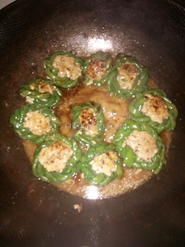 将豆角圈煎至两面金黄时，加入调好的料汁
