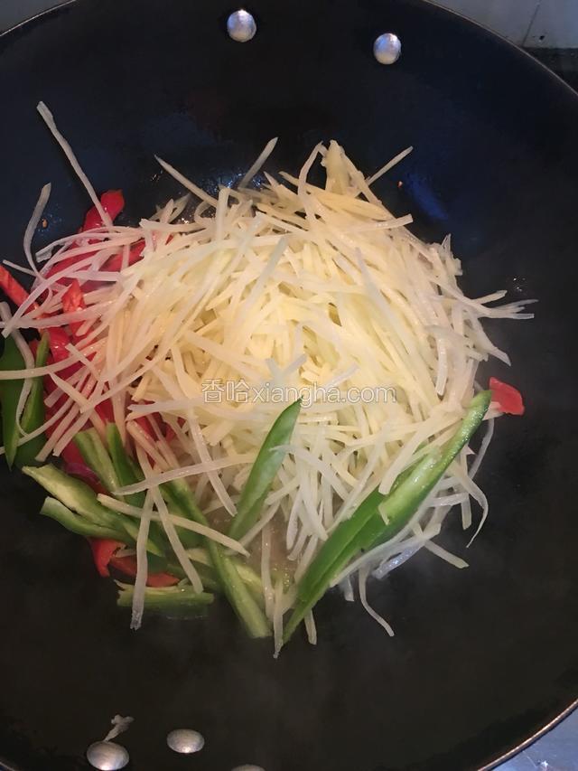 先倒入土豆丝和尖椒，红辣椒爆炒，加入适量的辣酱，十三香，鸡精，生抽翻炒均匀。