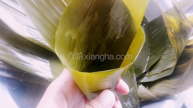 泡软的粽叶减去根部硬的地方卷成漏斗型，底部不要有漏洞！