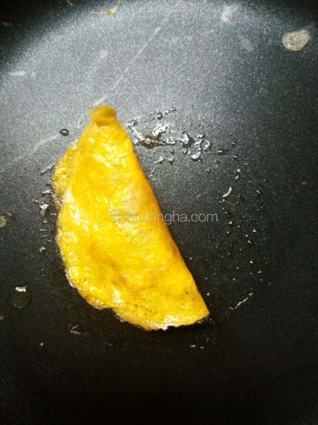 再折叠过来，压紧边缘，如果蛋皮过熟压不紧边缘就弄点生蛋液封住边缘口，一般在蛋皮七分熟时就折叠过来，是刚好可以按紧封住边缘的。