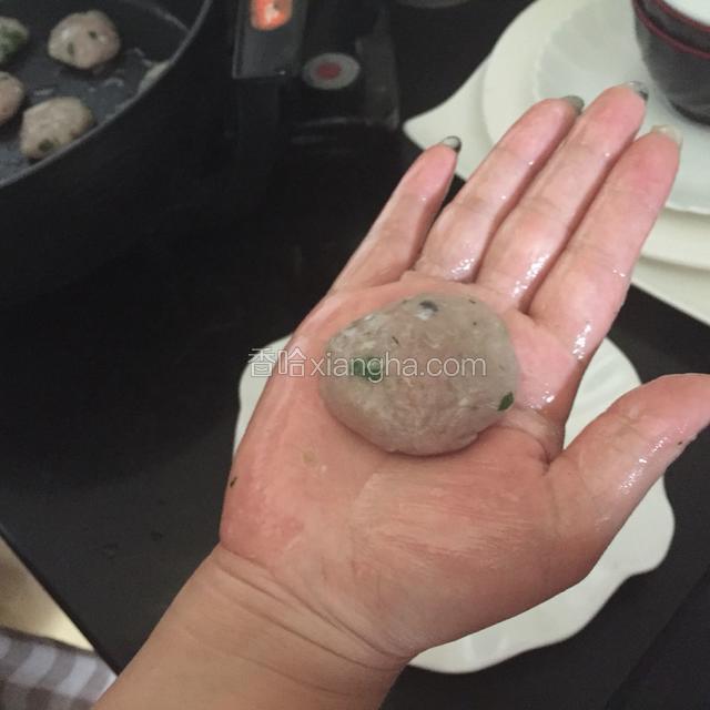 手掌上沾少许油，取一小坨肉糜搓成圆球再压成饼状